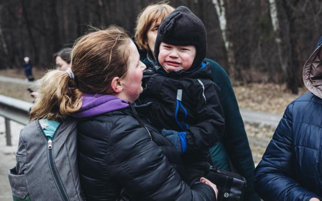 Un niño llora mientras espera para cruzar el río de Irpin, a 5 de marzo de 2022. Un niño llora mientras espera para cruzar el río de Irpin, a 5 de marzo de 2022.