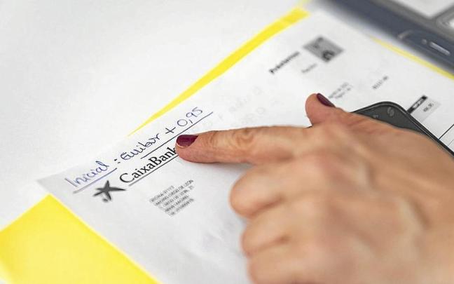 Una mujer mira los detalles de su hipoteca firmada con su entidad bancaria. | FOTO: E. PRESS Una mujer mira los detalles de su hipoteca firmada con su entidad bancaria. | FOTO: E. PRESS