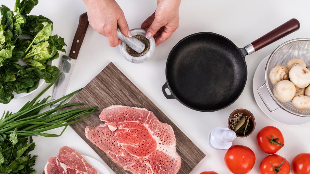 Persona cocinando un plato con carne.