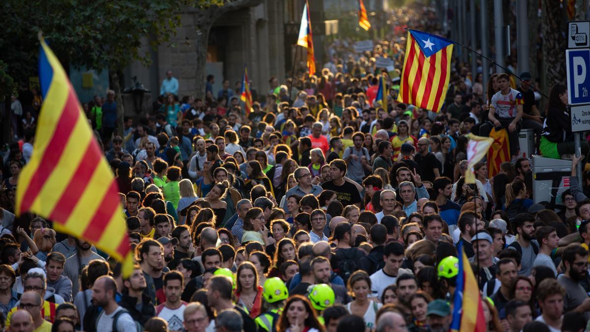 Una multitud de personas se concentra y ondea esteladas.