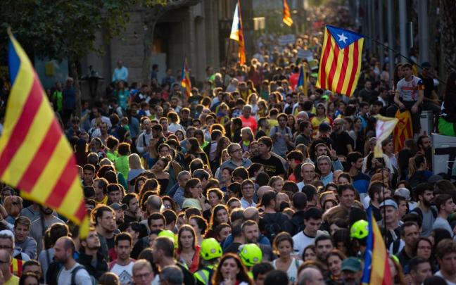 Una multitud de personas se concentra y ondea esteladas.