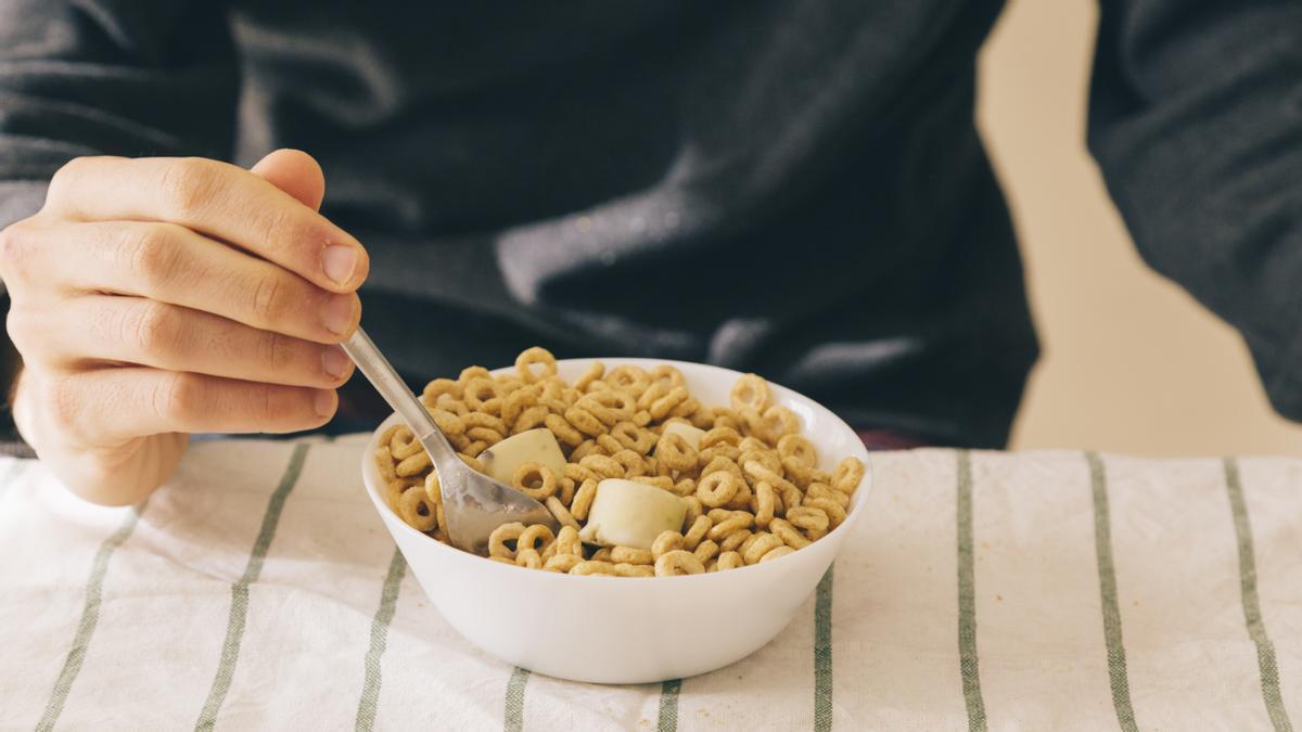 Un hombre se prepara para comer un bol de cereales.