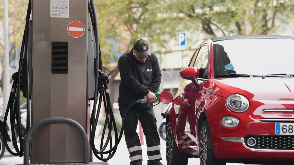 Una persona echa combustible en una gasolinera