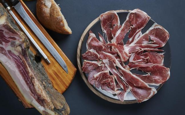 Un plato de jamón ibérico cortado a cuchillo por un experto cortador.