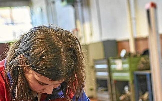 Una joven arregla un motor en un taller. | FOTO: E. P.