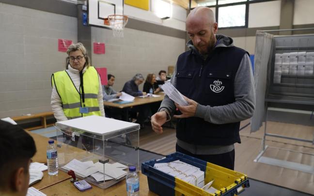 Un empleado de correos entrega votos por correo en una mesa electoral. / Luis Tejido Un empleado de correos entrega votos por correo en una mesa electoral.