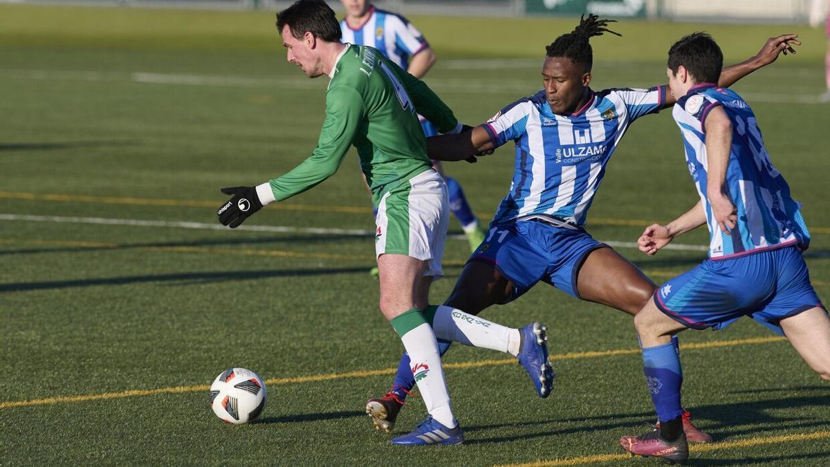 Un jugador del San Juan trata de proteger el esférico ante la presencia de dos futbolistas del Cirbonero.