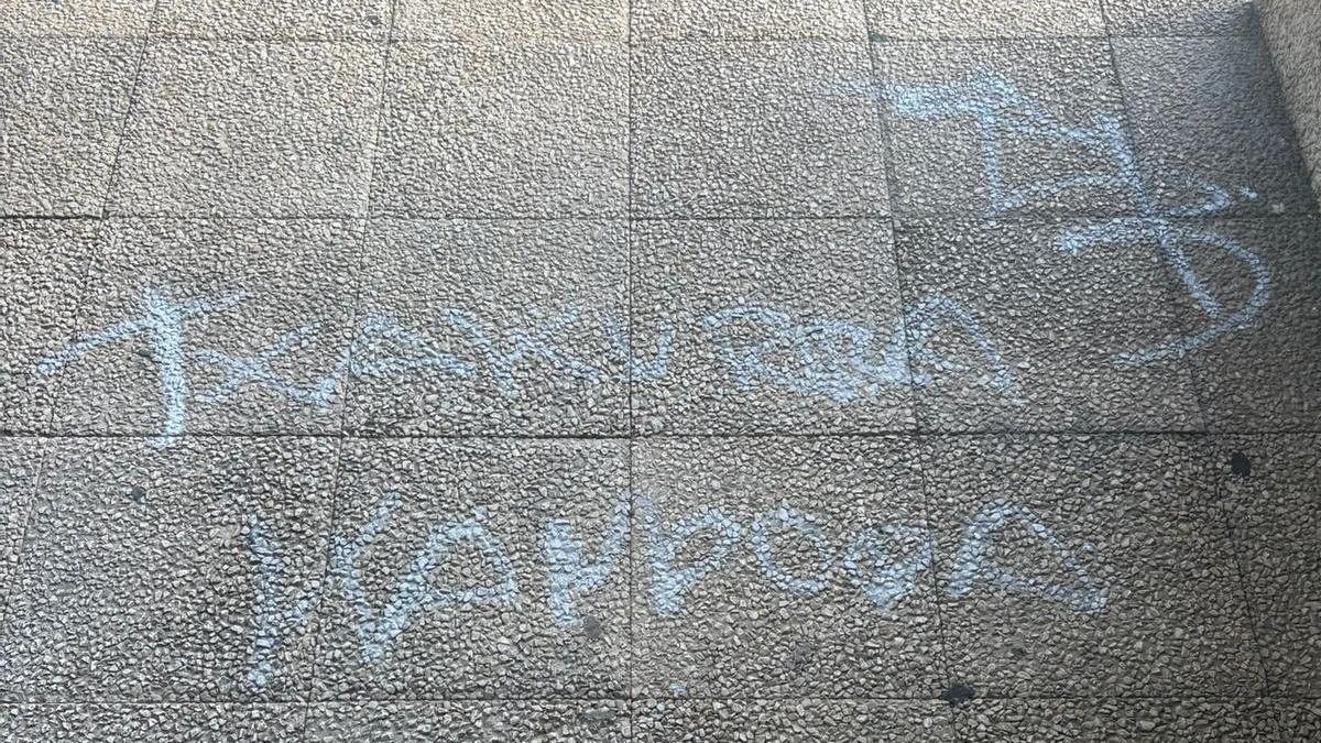 Pintada ante la casa de un ertzaina en Gasteiz, donde se lee "txakurra kanpora", con un hacha y una serpiente en la parte superior derecha