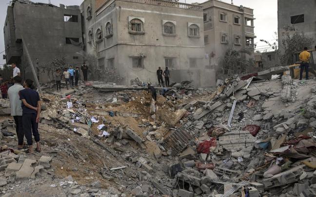 Palestinos buscan supervivientes tras el ataque israelí contra un edificio residencial.