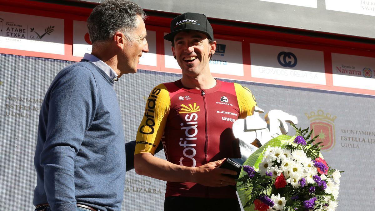 Miguel Indurain premia a Ion Izagirre en el podio.