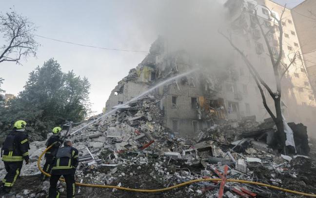 Los bomberos ucranianos sofocan las llamas de uno de los edificios atacados en Kiev.