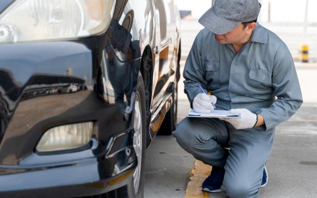 Un mecánico inspecciona un coche.