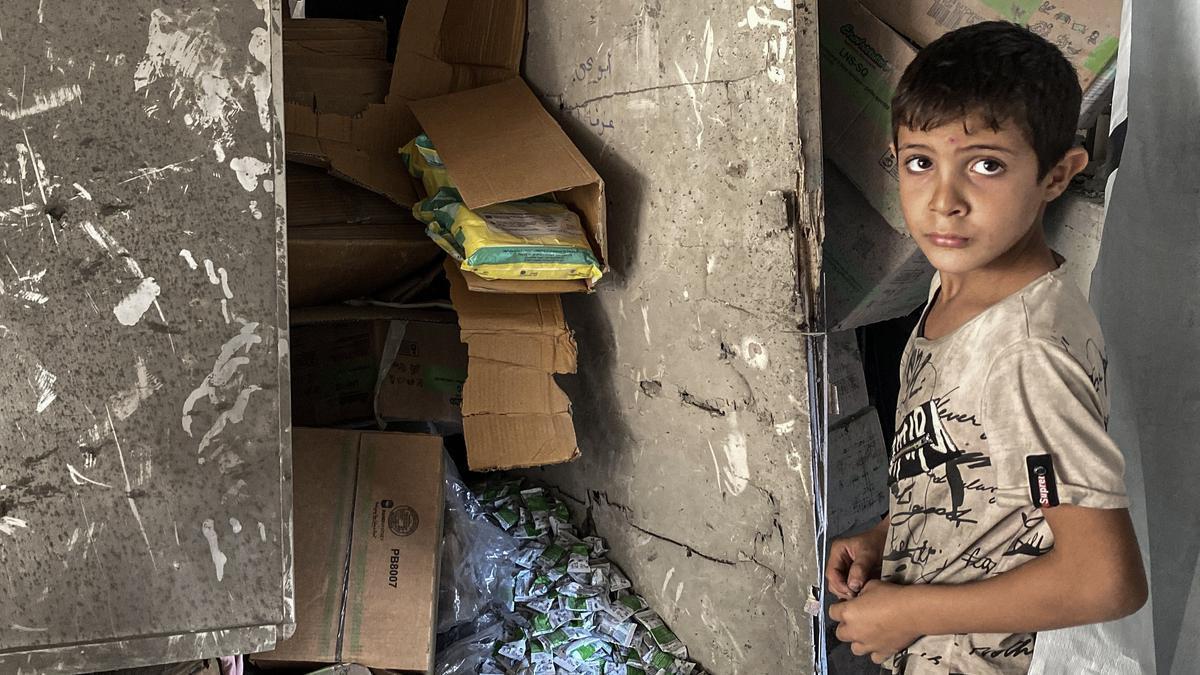 Un niño junto a los destrozos causados por un bombardeo israelí en una escuela de la Franja de Gaza.