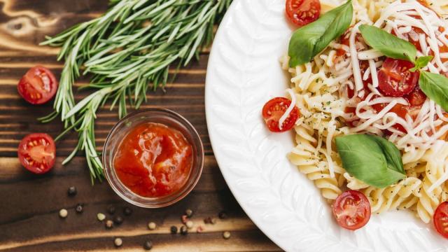 Plato de pasta con tomates cherry troceados.