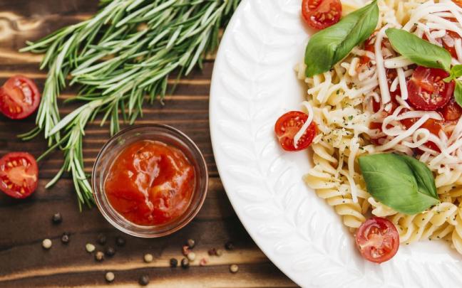 Plato de pasta con tomates cherry troceados.