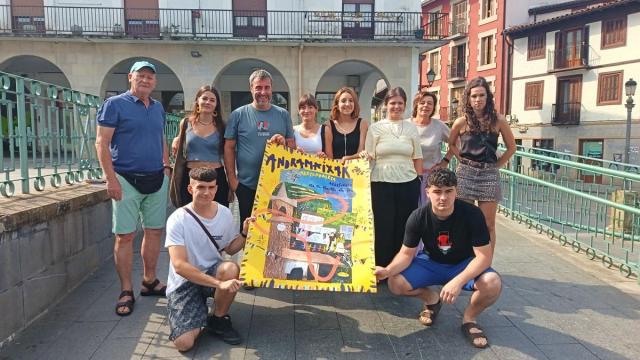 Representantes municipales, de la comisión de txosnas, del grupo de txistularis y la comparsa, junto con la autora del cartel, Amaiur Madinabeitia (cuarta por la izquierda), en la presentación del programa festivo.