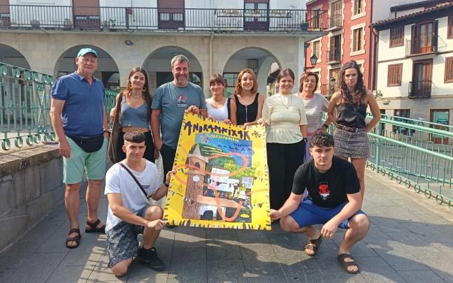 Representantes municipales, de la comisión de txosnas, del grupo de txistularis y la comparsa, junto con la autora del cartel, Amaiur Madinabeitia (cuarta por la izquierda), en la presentación del programa festivo.