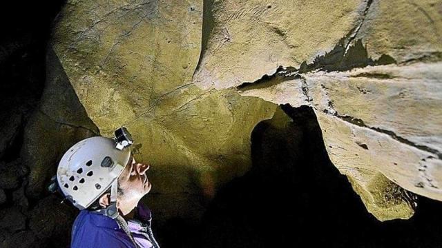 Un hombre contempla los grabados hallados en 2015 en las cuevas de Aitzbitarte de Errenteria.