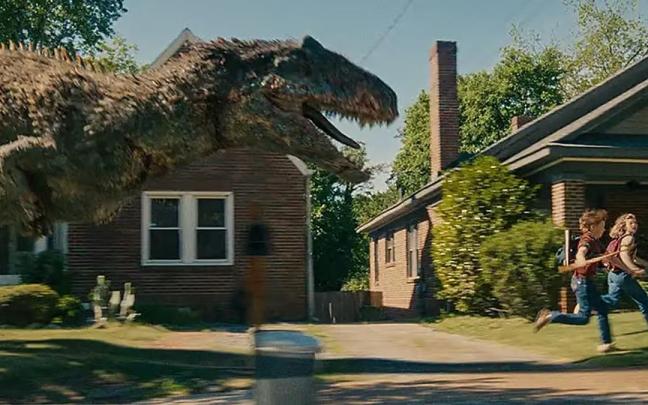 Un dinosaurio irrumpe en la aparente tranquilidad de un barrio residencial en 