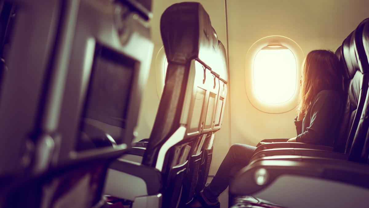 Una mujer sentada en el asiento de un avión.