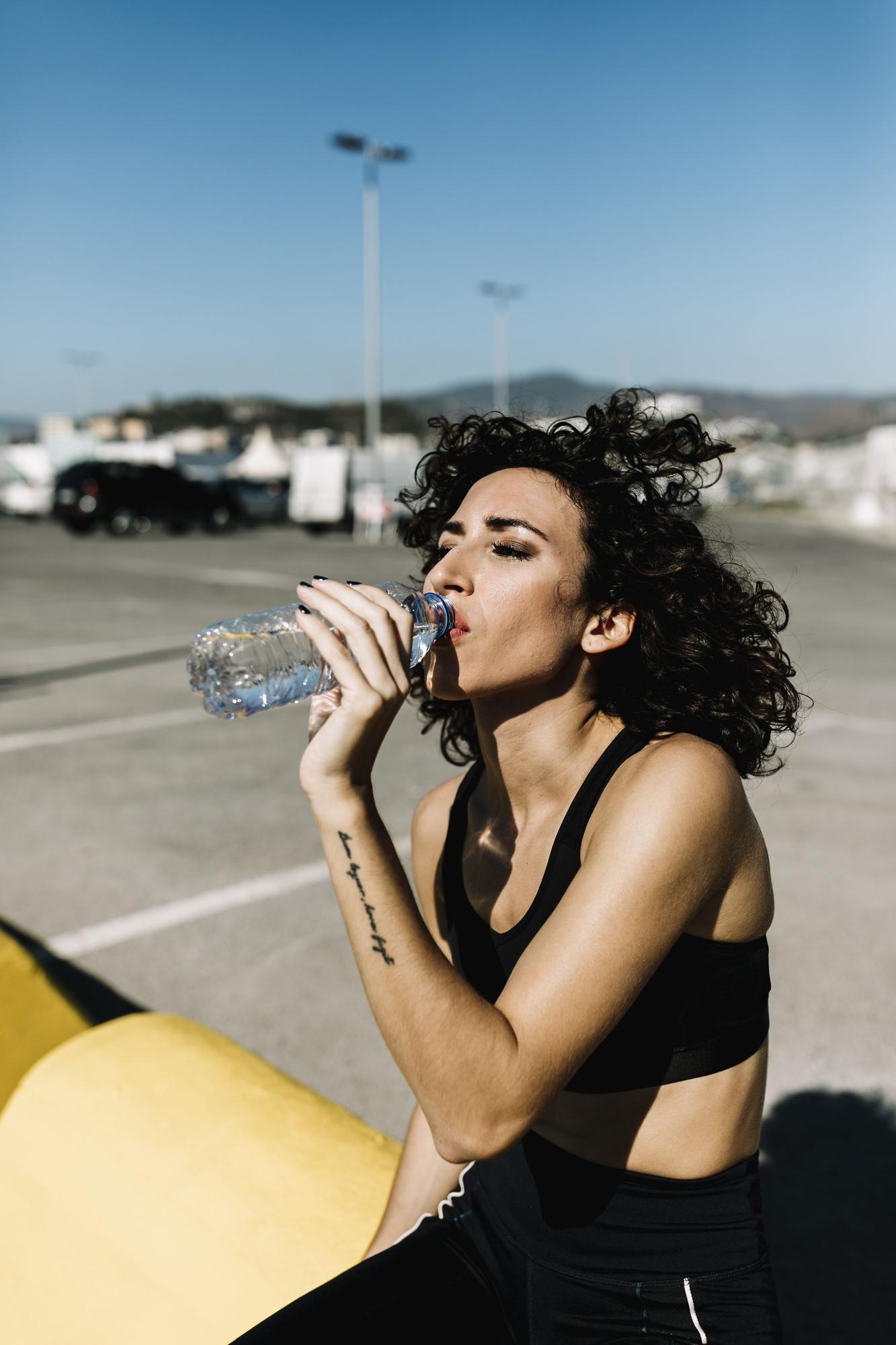 Una joven bebe de una botella de agua.