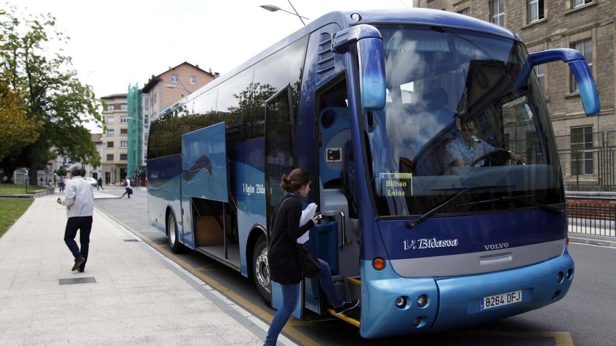 Joven ajena a la infomación subiendo a uno de los autobús de Altube que lleva a los estudiantes a Bilbao y Leioa