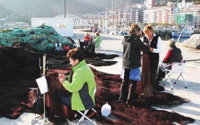 Un grupo de rederas repara las artes de pesca en el puerto de Ondarroa.