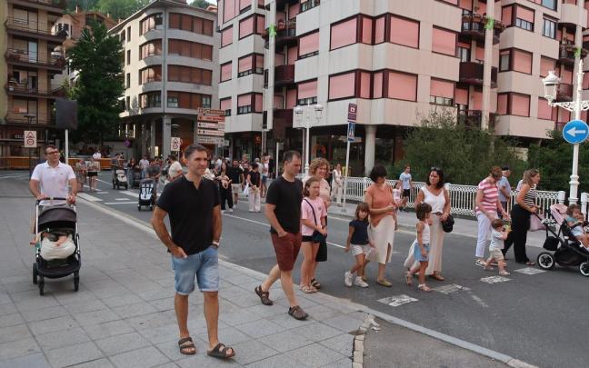 Vecinos cruzando de un lado al otro del barrio, en la kalejira de los gigantes y los dulzaineros.