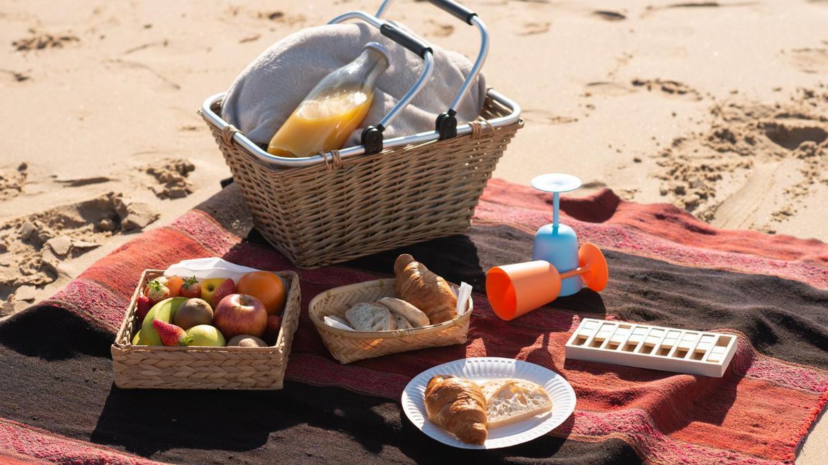 Unos platos de comida encima de una toalla en una playa