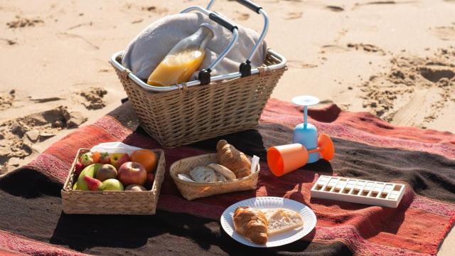 Unos platos de comida encima de una toalla en una playa