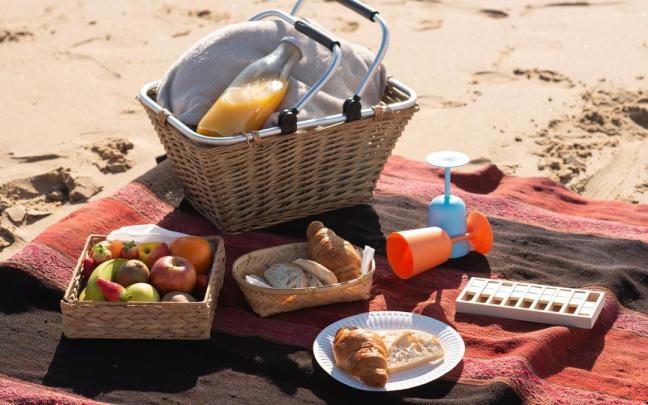 Unos platos de comida encima de una toalla en una playa