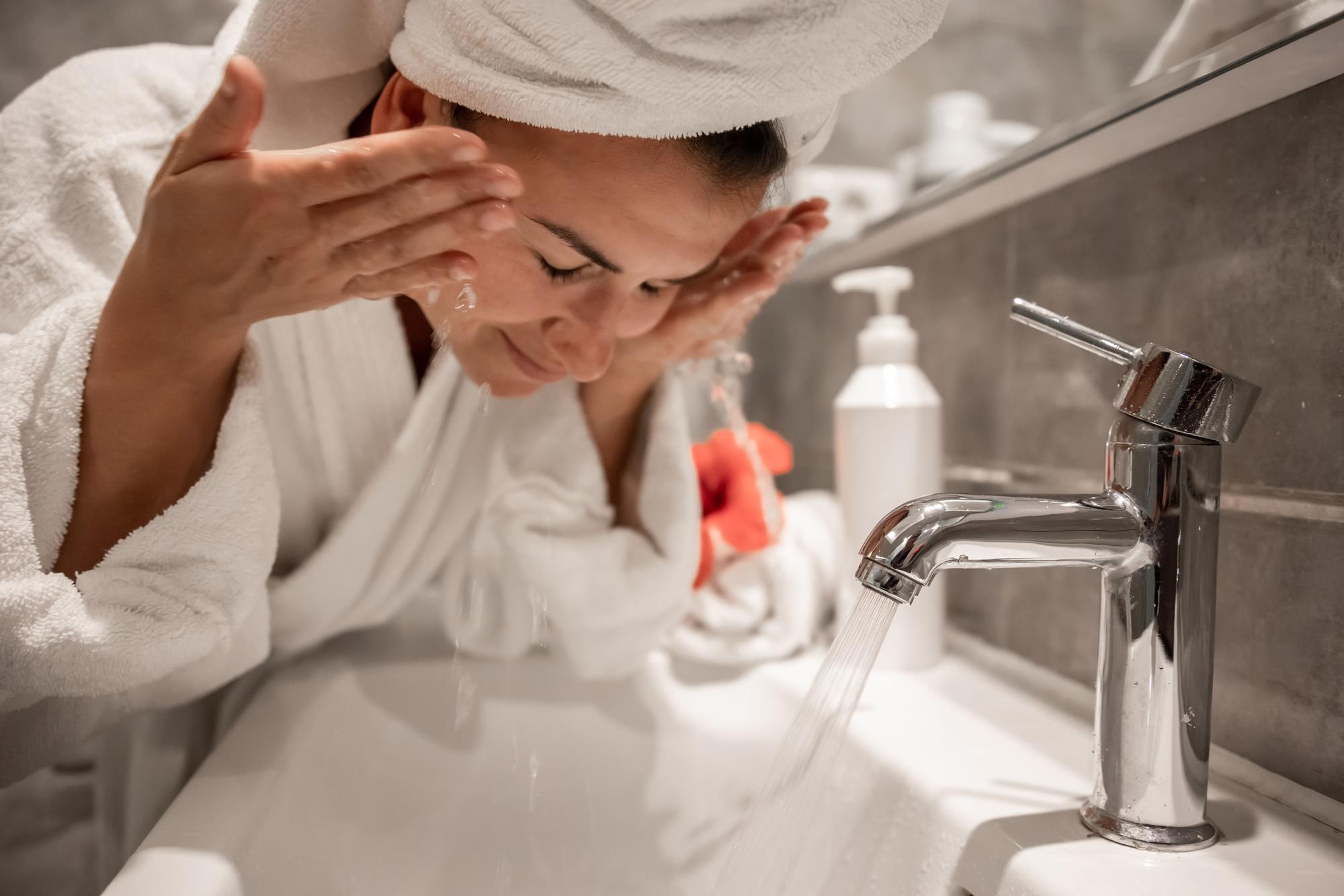 Chica se lava la cara como parte de su rutina de cuidado facial.