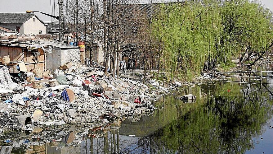 Un vertedero en China, cuya basura cae en un canal que acaba inundado por toneladas de desperdicios. | FOTO: EFE