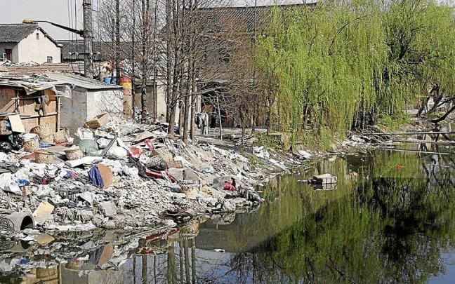 Un vertedero en China, cuya basura cae en un canal que acaba inundado por toneladas de desperdicios. | FOTO: EFE
