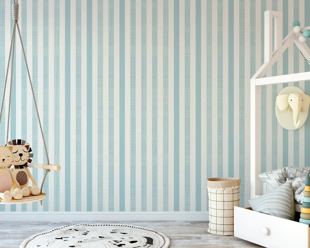 Habitación infantil con papel a rayas en color azul cielo y blanco.