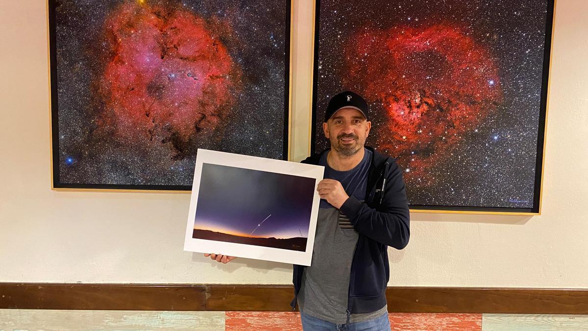 Alfredo Sayalero, astofotógrafo zarauztarra, en el bar Euskalduna con tres de sus fotografías que se podrán ver en la exposición.