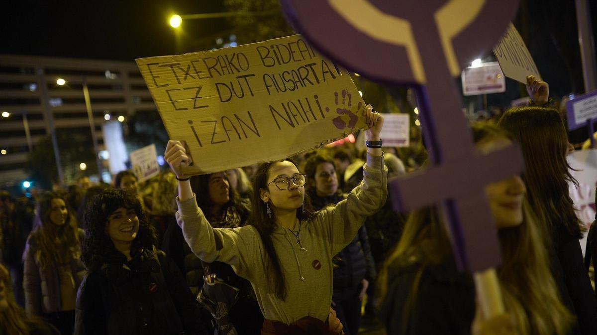 Una joven sostiene un lema para gritar libertad de camino a casa.