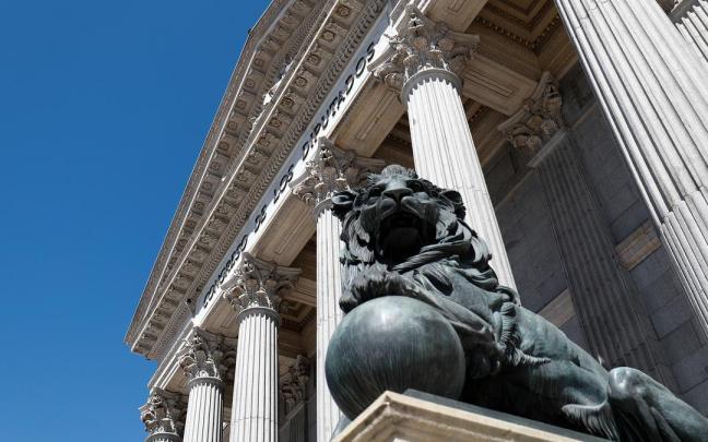 Uno de los emblemáticos leones que se encuentran delante de la fachada del Congreso de los Diputados en la Plaza de las Cortes de Madrid.