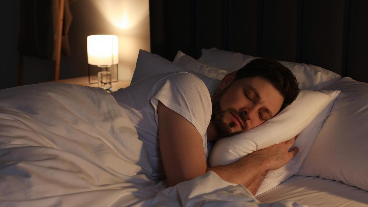 Un hombre duerme plácidamente en la cama.