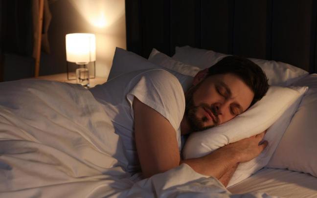 Un hombre duerme plácidamente en la cama.