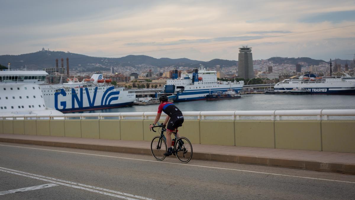 Una persona en bici frente a la terminal de cruceros del Puerto de Barcelona.