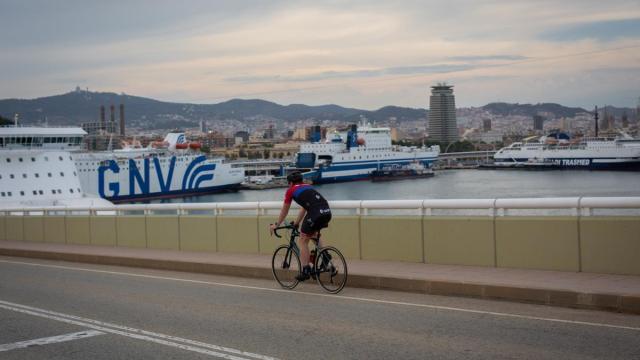 Una persona en bici frente a la terminal de cruceros del Puerto de Barcelona.
