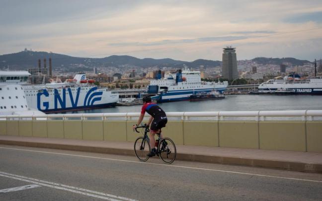 Una persona en bici frente a la terminal de cruceros del Puerto de Barcelona.