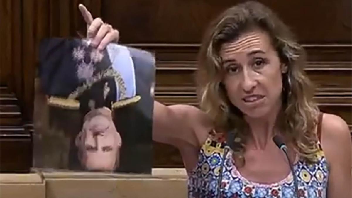 La parlamentaria de la CUP Laia Estrada muestra una foto boca abajo de Felipe VI antes de romperla.