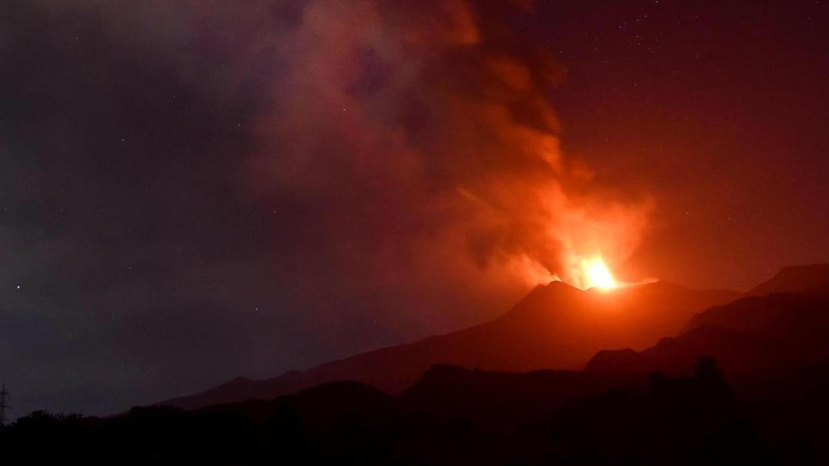 La lava y la gran columna de cenizas expulsada por el volcán Etna.