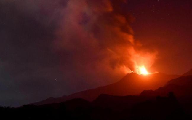La lava y la gran columna de cenizas expulsada por el volcán Etna.