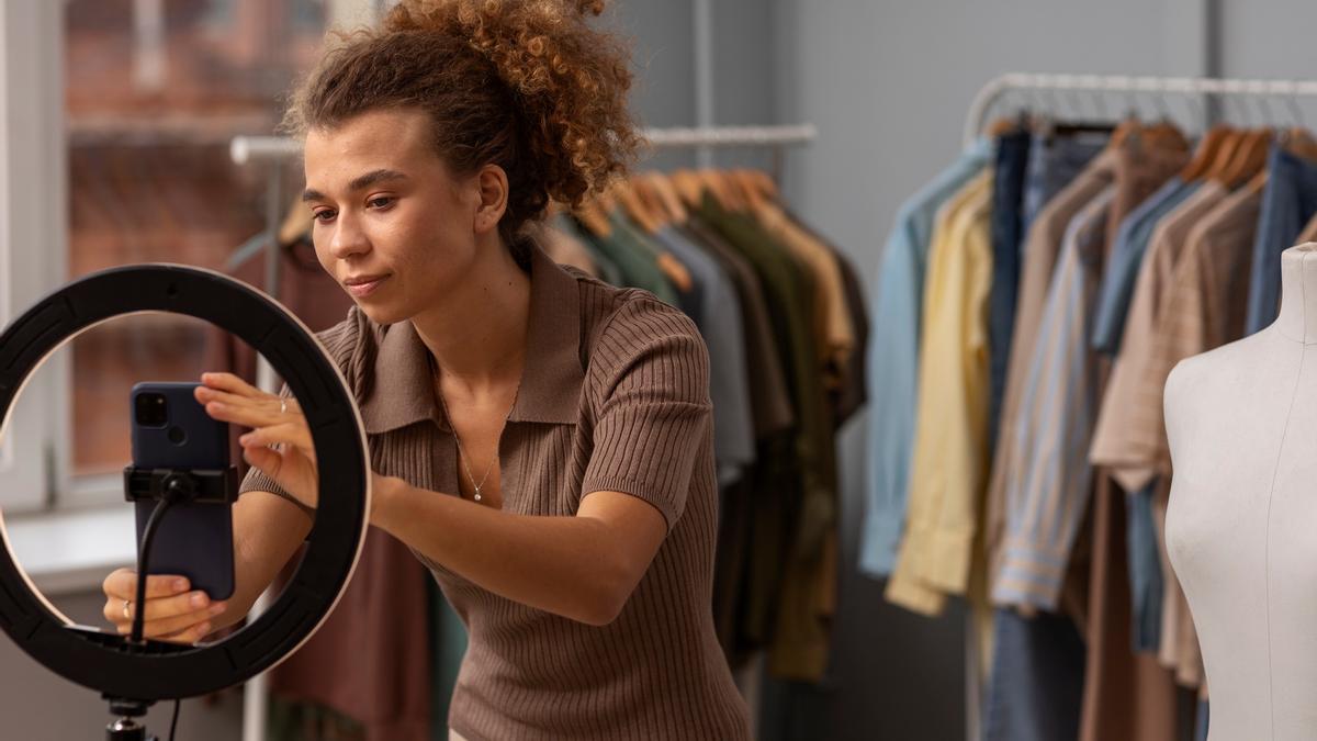 La dueña de una tienda coloca el móvil para fotografiar sus productos.