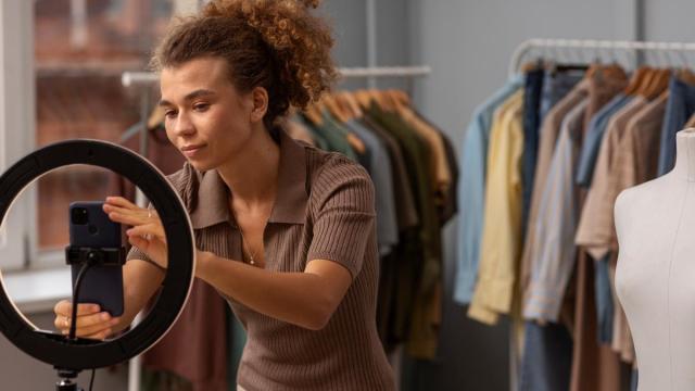 La dueña de una tienda coloca el móvil para fotografiar sus productos.