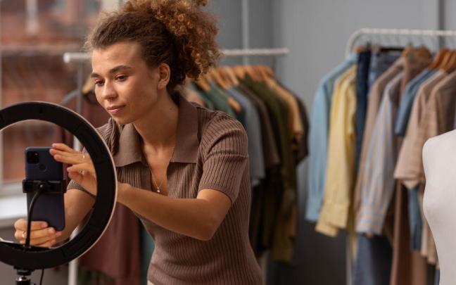 La dueña de una tienda coloca el móvil para fotografiar sus productos.