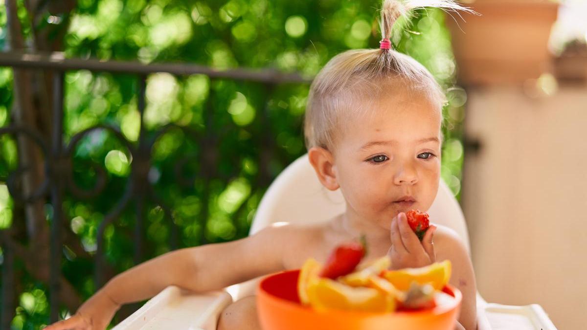 Niña come fruta en verano.